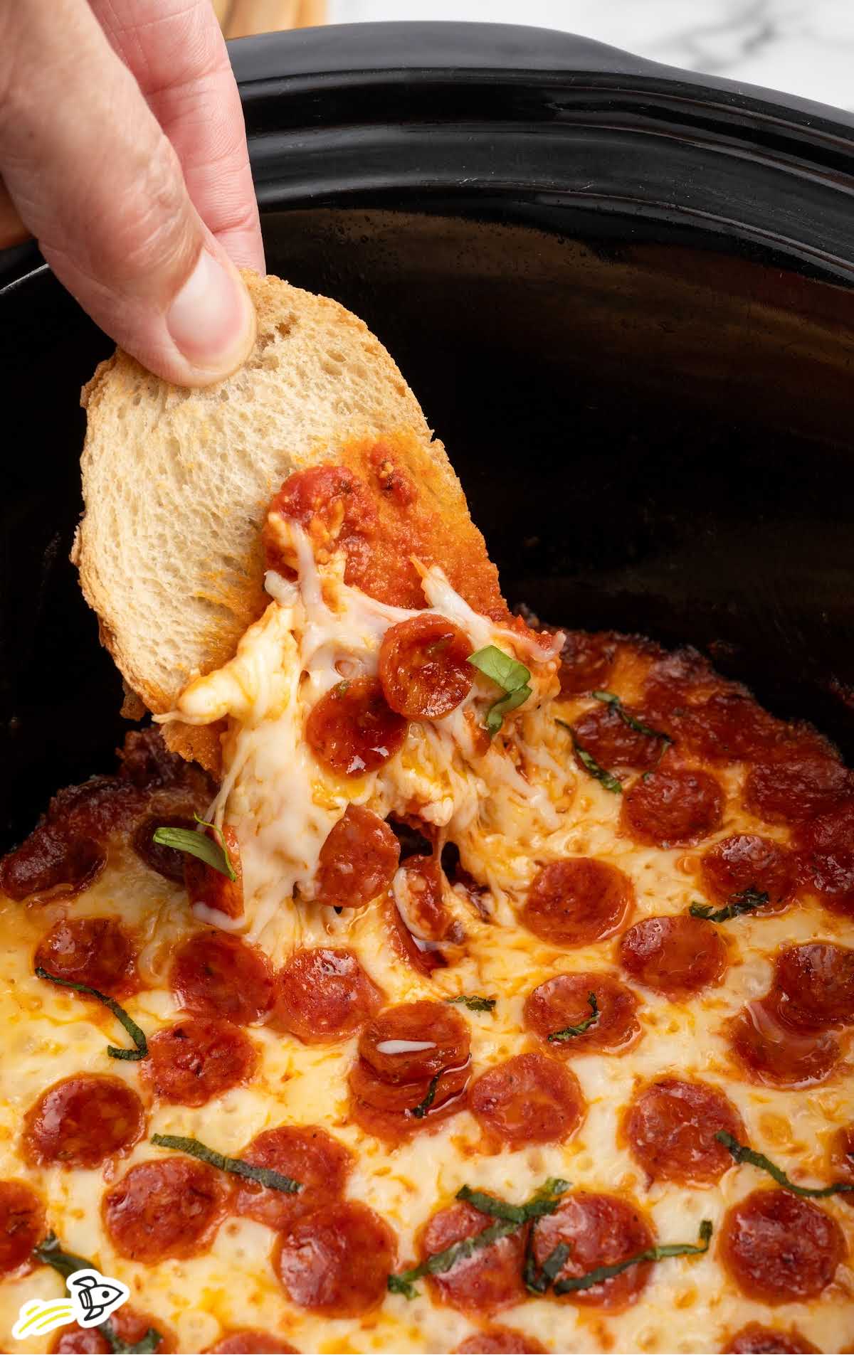 a Slow Cooker of Pizza Dip garnished with basil