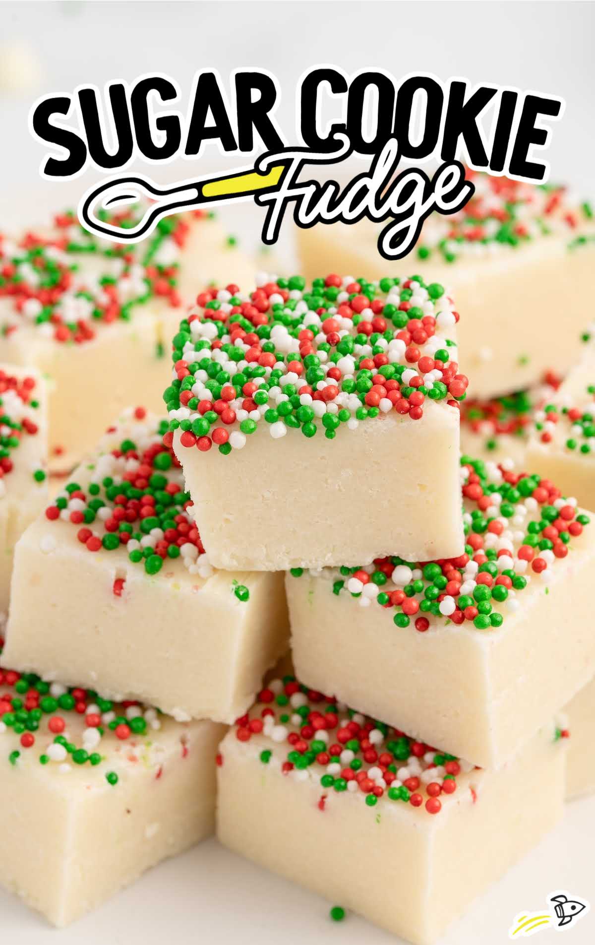 Sugar Cookie Fudge with christmas sprinkles stacked on top of each other