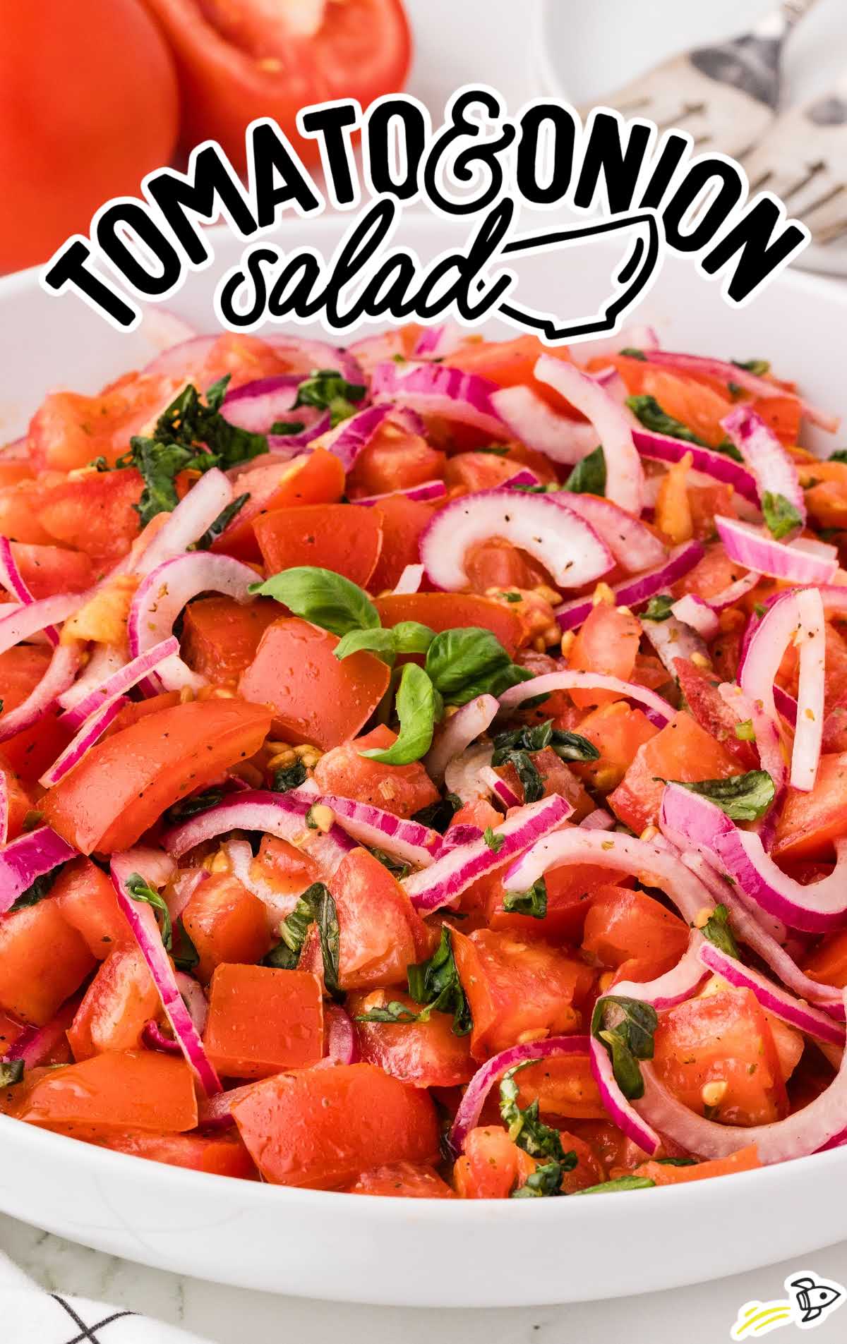 a bowl of Tomato and Onion Salad topped with basil