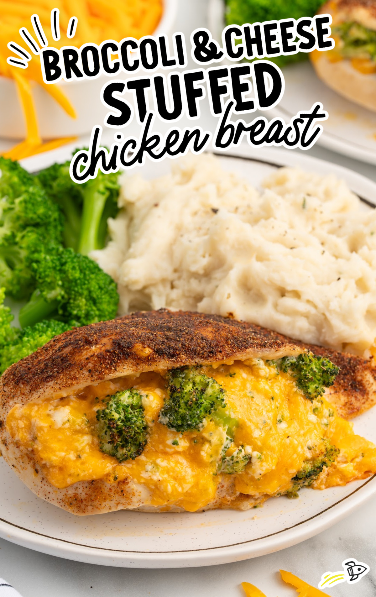 A dinner plate covered in Broccoli and Cheese Stuffed Chicken Breast, potatoes, and broccoli.