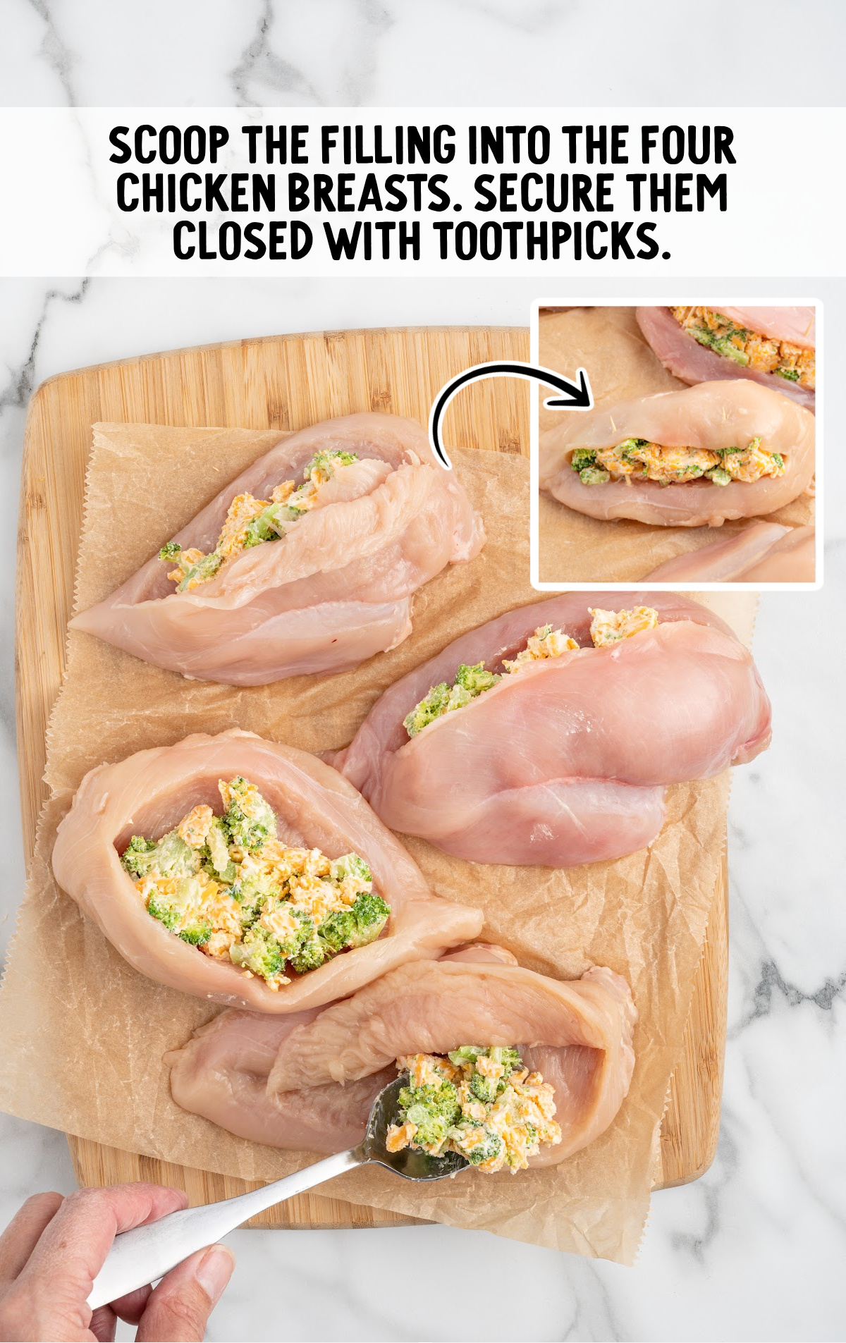 A cutting board covered in chicken breasts that are cut open and filled with filling.