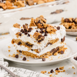 A slice of cookie lasagna on a white plate.