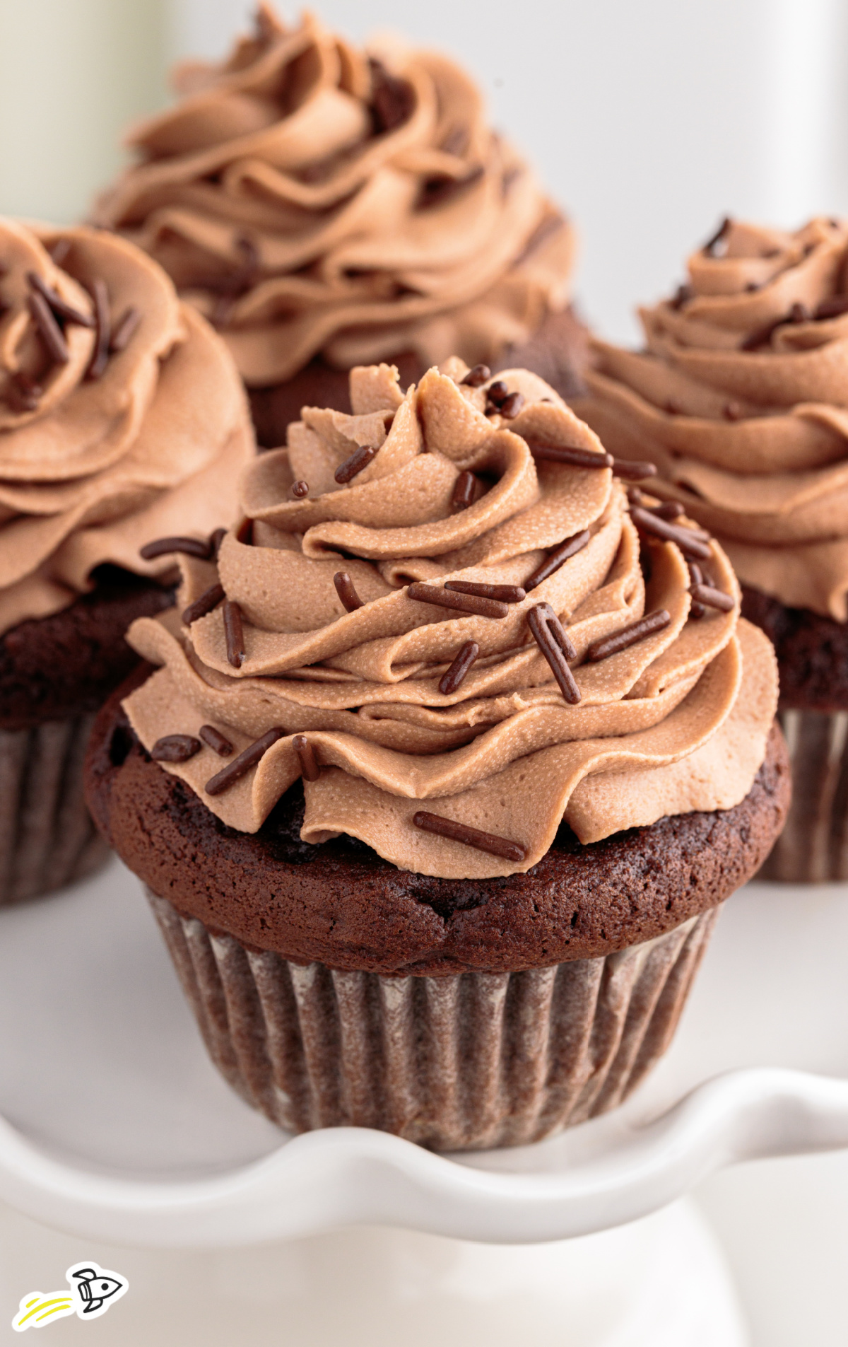 Nutella Cupcakes on a cake stand with frosting and sprinkles. 