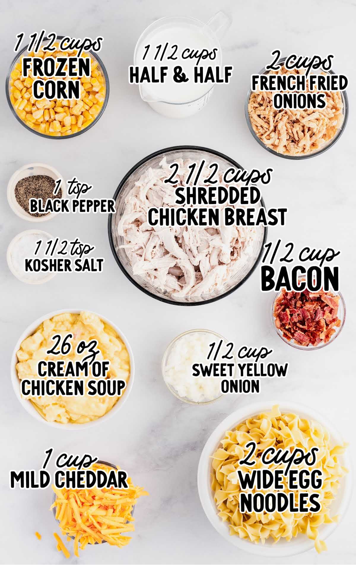 Labeled flat lay of ingredients for ultimate chicken casserole including egg noodles, shredded chicken, corn, cream of chicken soup, and fried onions.