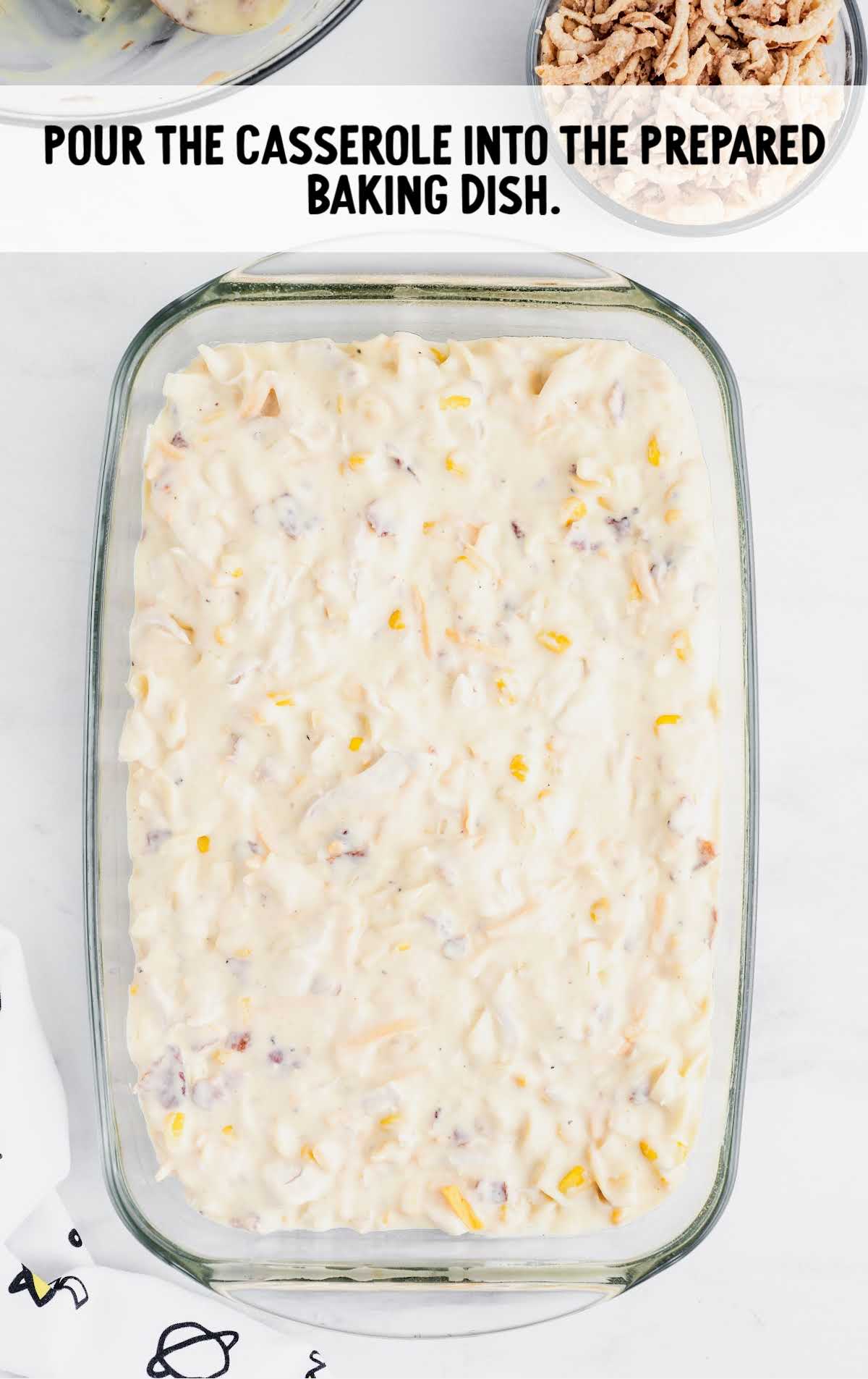 Unbaked casserole mixture spread evenly in a glass baking dish, ready to go into the oven.