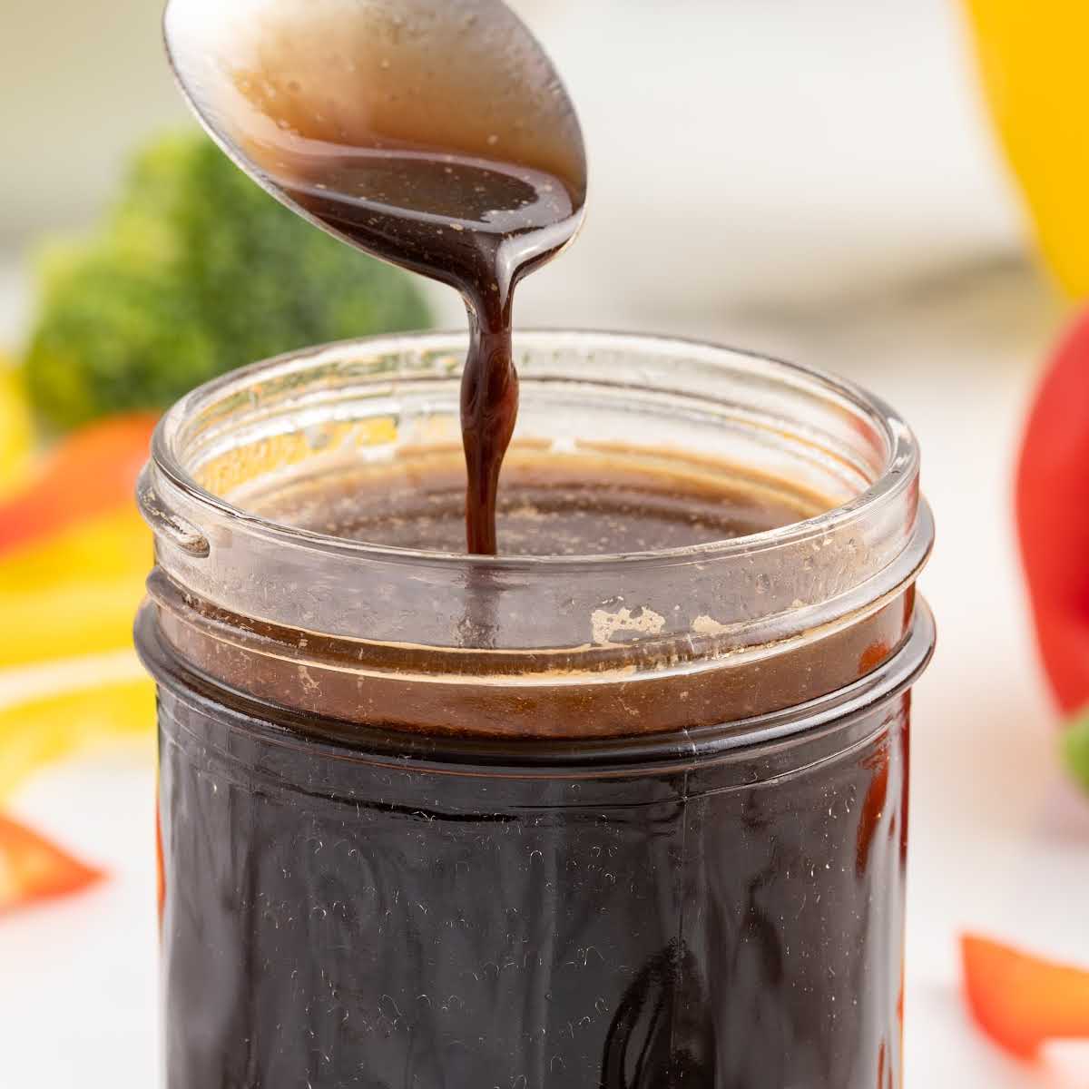 a spoonful of 3 Ingredient Stir Fry Sauce being dripped into the jar of sauce