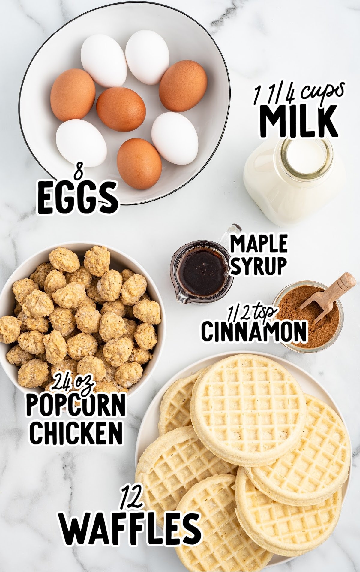 Flat lay of labeled ingredients for chicken and waffle casserole including eggs, milk, maple syrup, cinnamon, popcorn chicken, and frozen waffles.