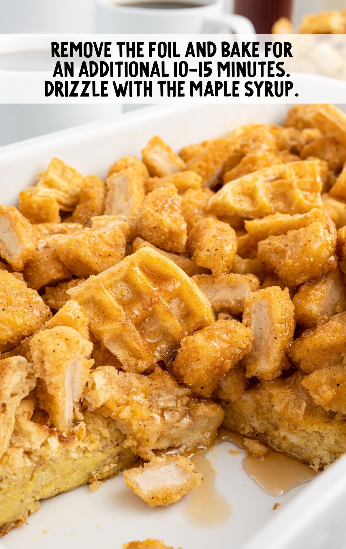 Close-up of baked chicken and waffle casserole after removing the foil, golden brown and drizzled with maple syrup.