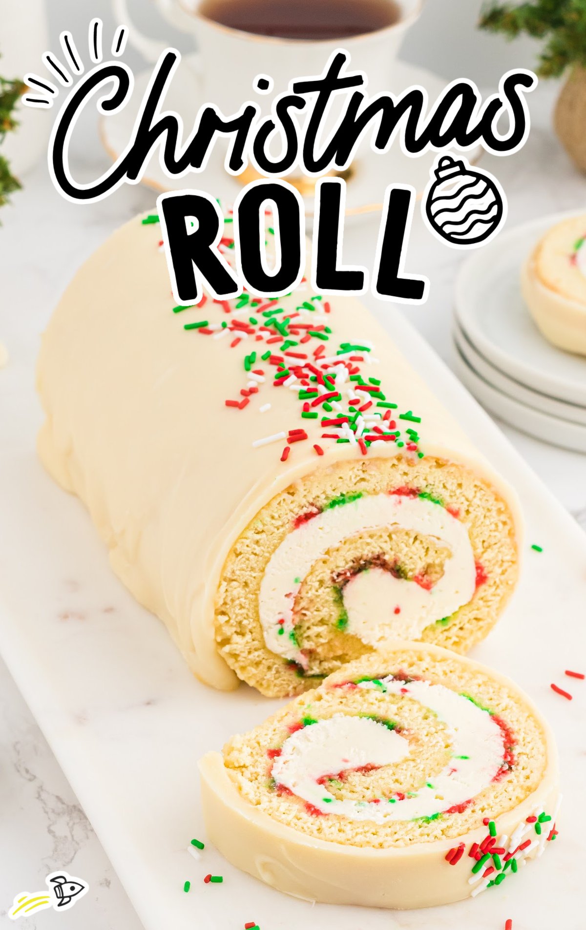 A Christmas roll on a white serving plate with a slice cut off the end to show the swirled roll inside. 