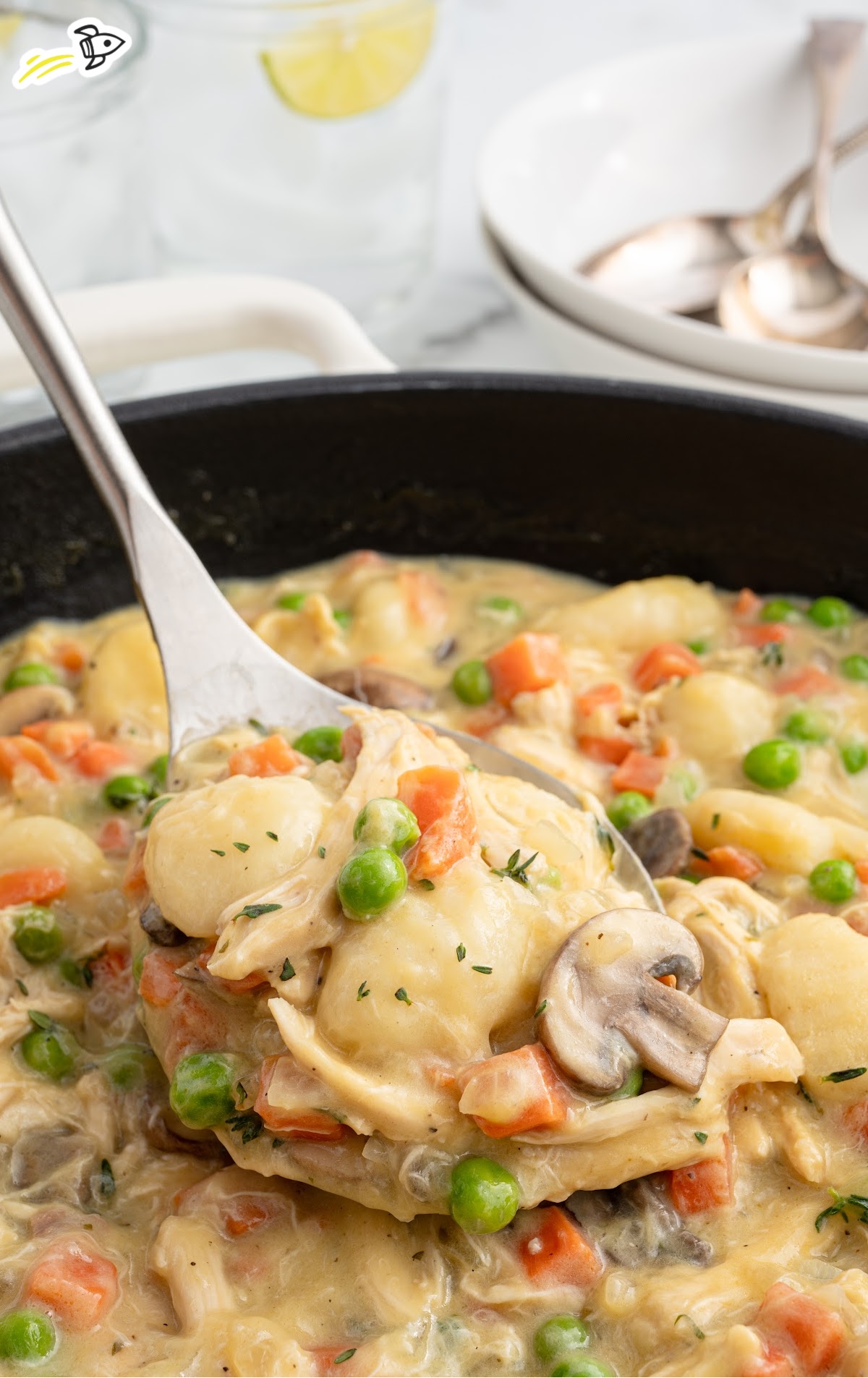 A cast iron skillet with a ladle scooping out a serving.