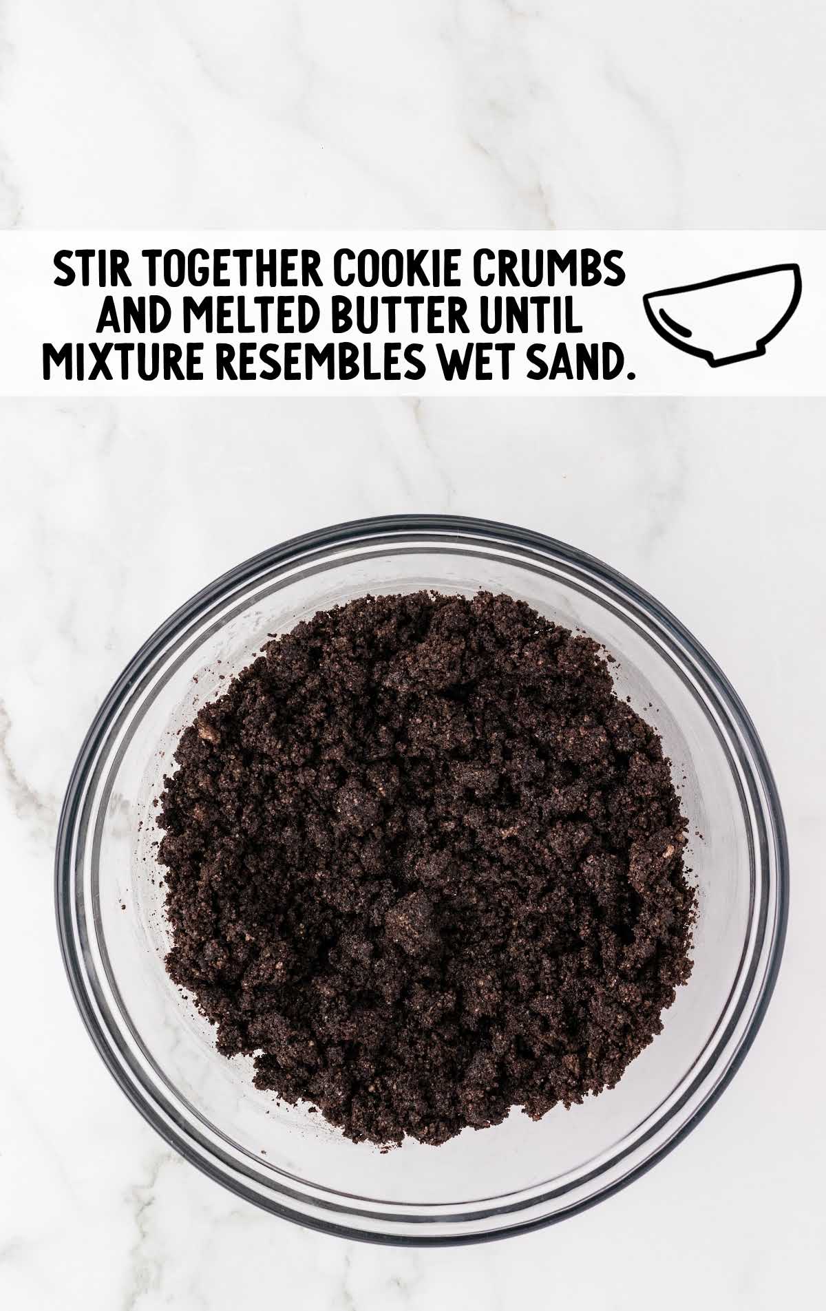 finely ground chocolate cookie crumbs with melted butter combined in a bowl