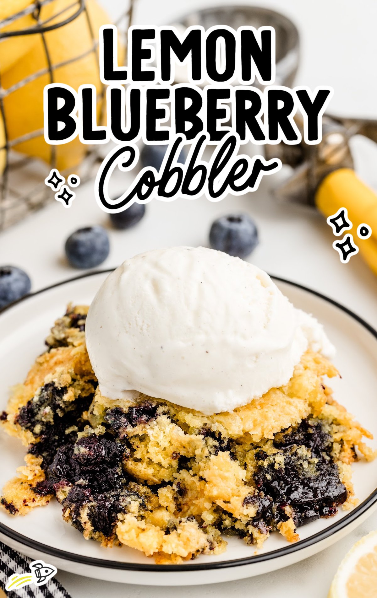 A serving of Lemon Blueberry Cobbler on a dessert plate with whipped vanilla ice cream 