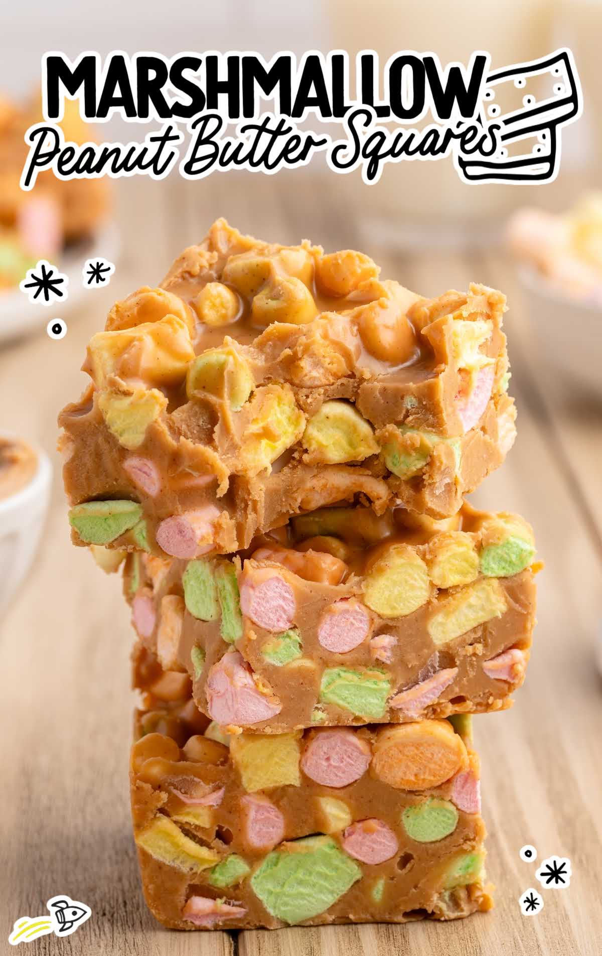 Stacked peanut butter marshmallow squares with colorful fruity marshmallows surrounded by creamy butterscotch coating.
