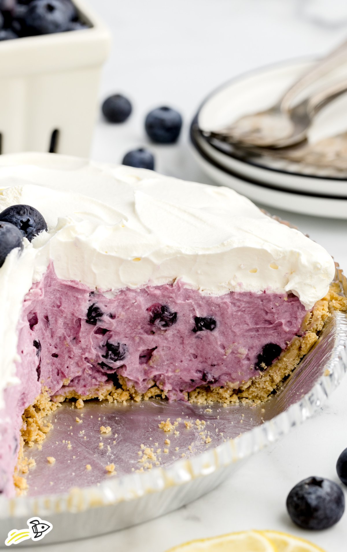 A No Bake Blueberry Pie. in a pie plate with a slice missing from it.