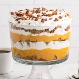 Close-up of pumpkin spice trifle with layers of cake, pumpkin cheesecake, and whipped topping