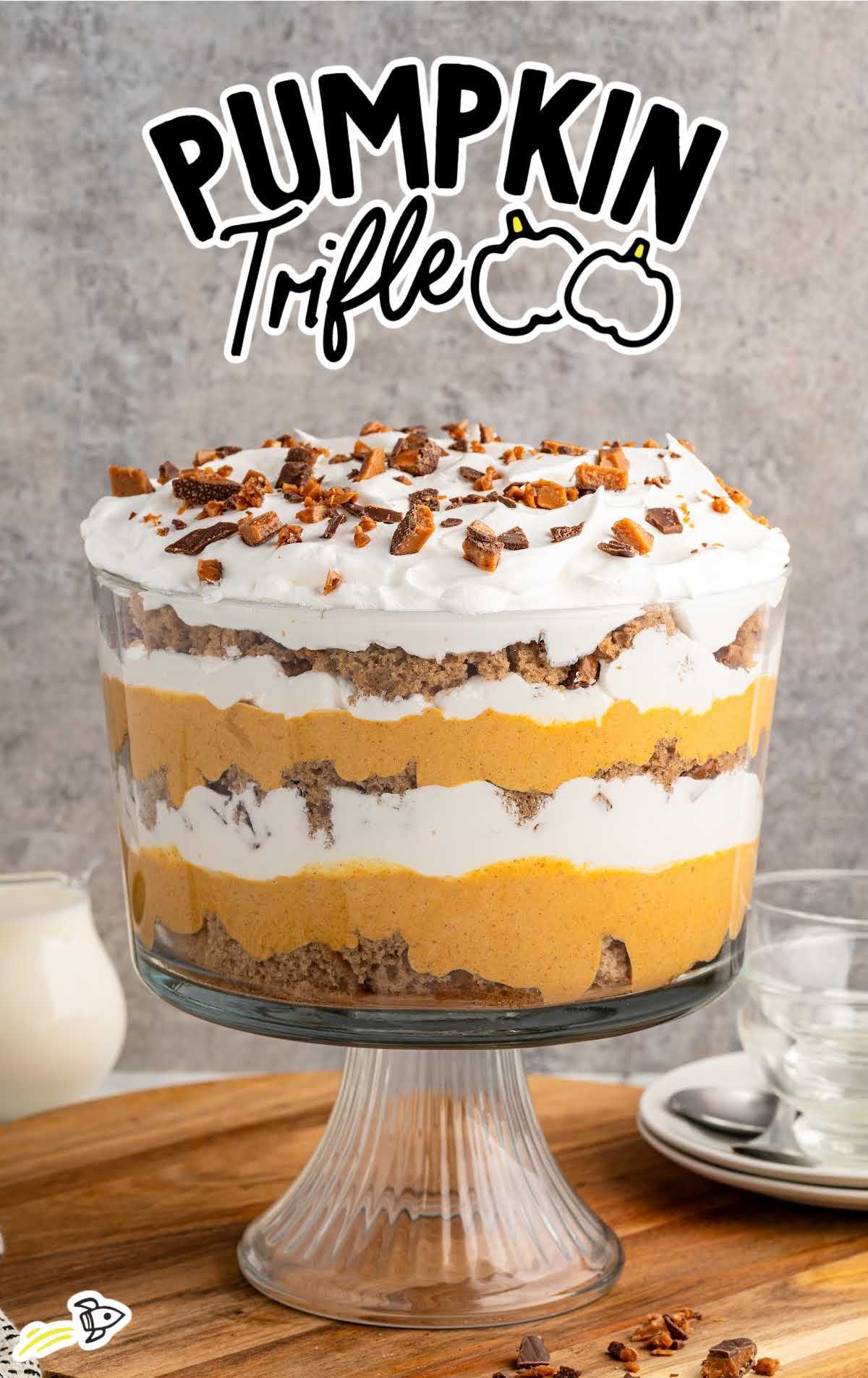 Pumpkin trifle dessert in a glass dish with visible layers of whipped cream and pumpkin filling