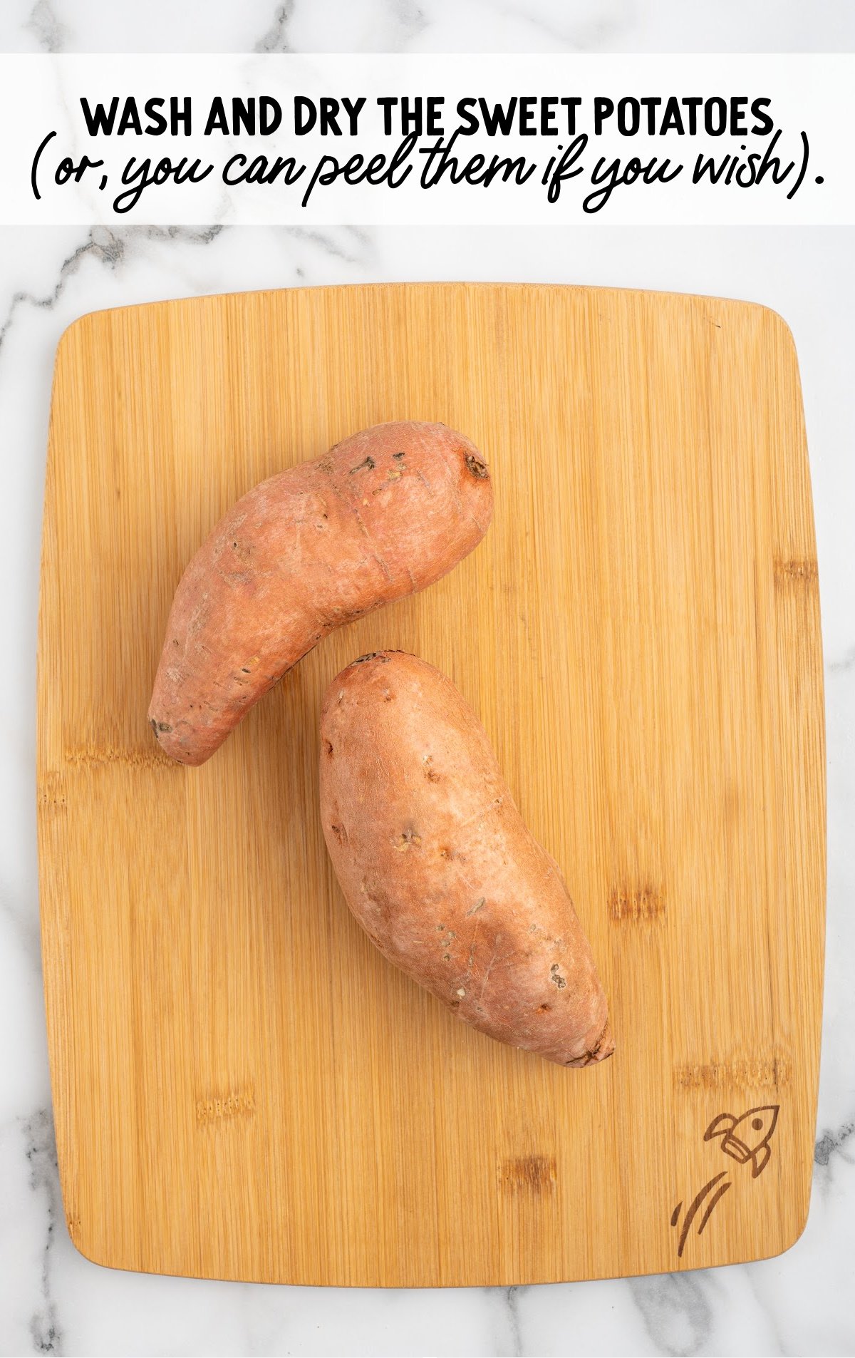 Sweet potatoes on a wooden cutting board after being washed and dried.