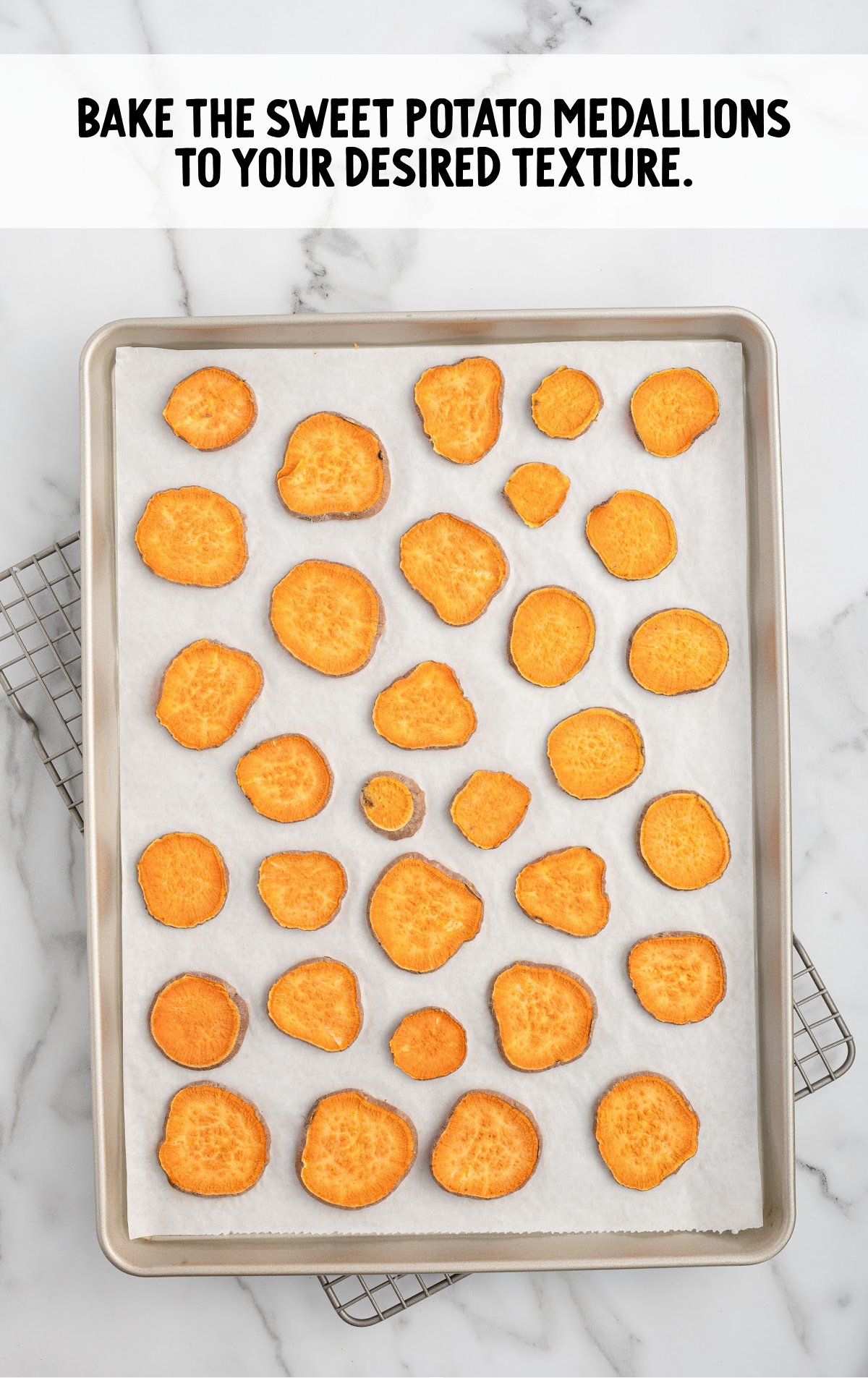 Sliced sweet potato pieces laid in a single file on a baking sheet.