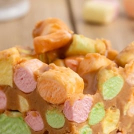 Close-up of colorful peanut butter marshmallow bars with text overlay reading โThe Best 5 Ingredient Marshmallow Peanut Butter Squares โ Ultra-Easy, No-Bake Dessert!โ