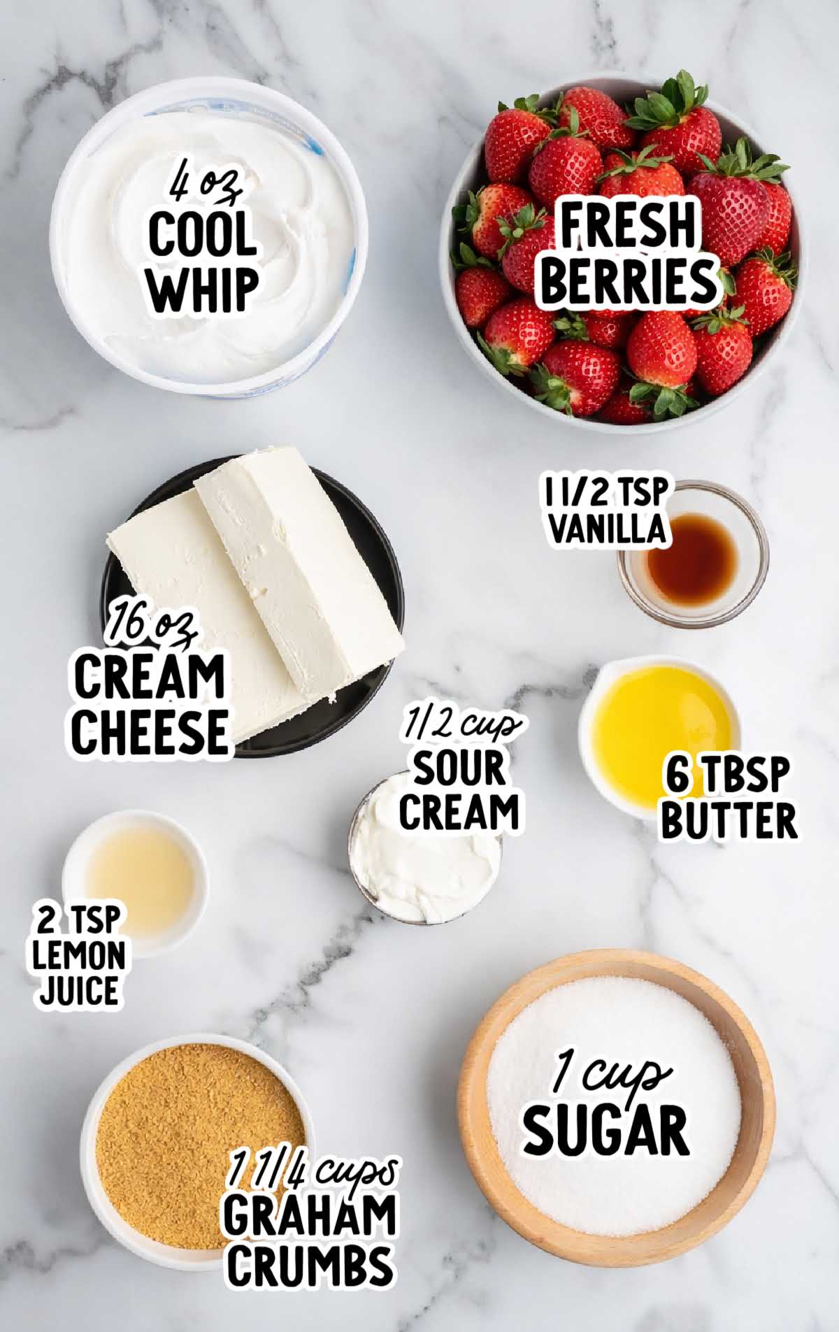 Ingredients for no bake cheesecake including cream cheese, Cool Whip, graham cracker crumbs, sugar, butter, sour cream, vanilla, lemon juice, and fresh strawberries