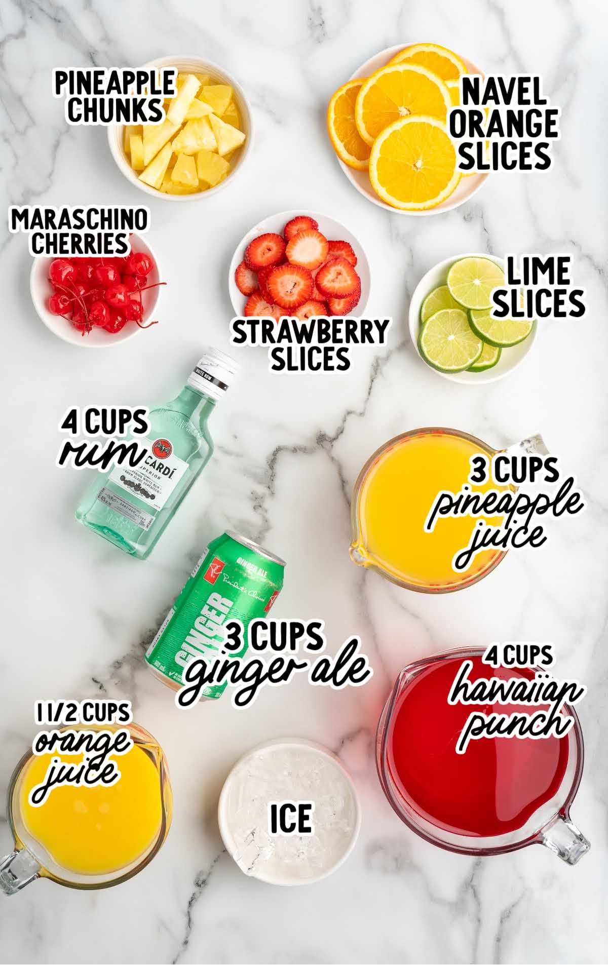 Overhead image showing labeled ingredients for party punch, including Hawaiian Punch, rum, pineapple juice, orange juice, ginger ale, ice, and fruit garnishes like orange, lime, strawberry, pineapple chunks, and maraschino cherries arranged on a marble surface.