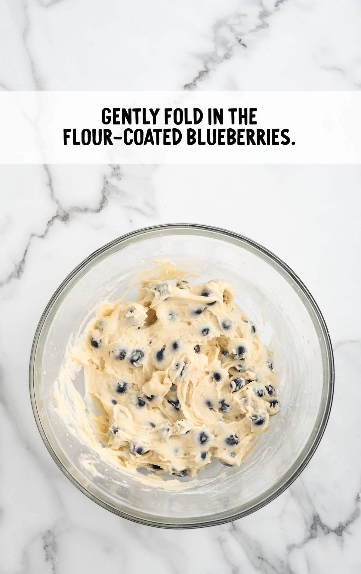 The flour coated blueberries are mixed into the batter.