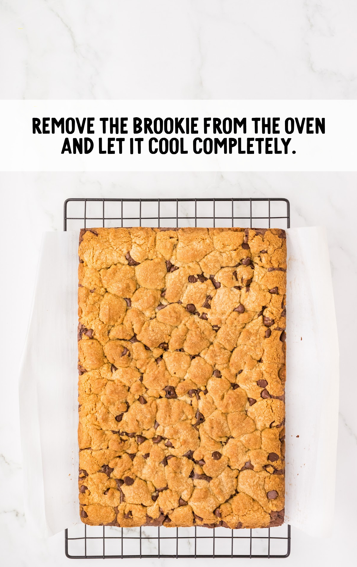 The brookie is removed from the pan, and sitting on a cooling rack to cool.