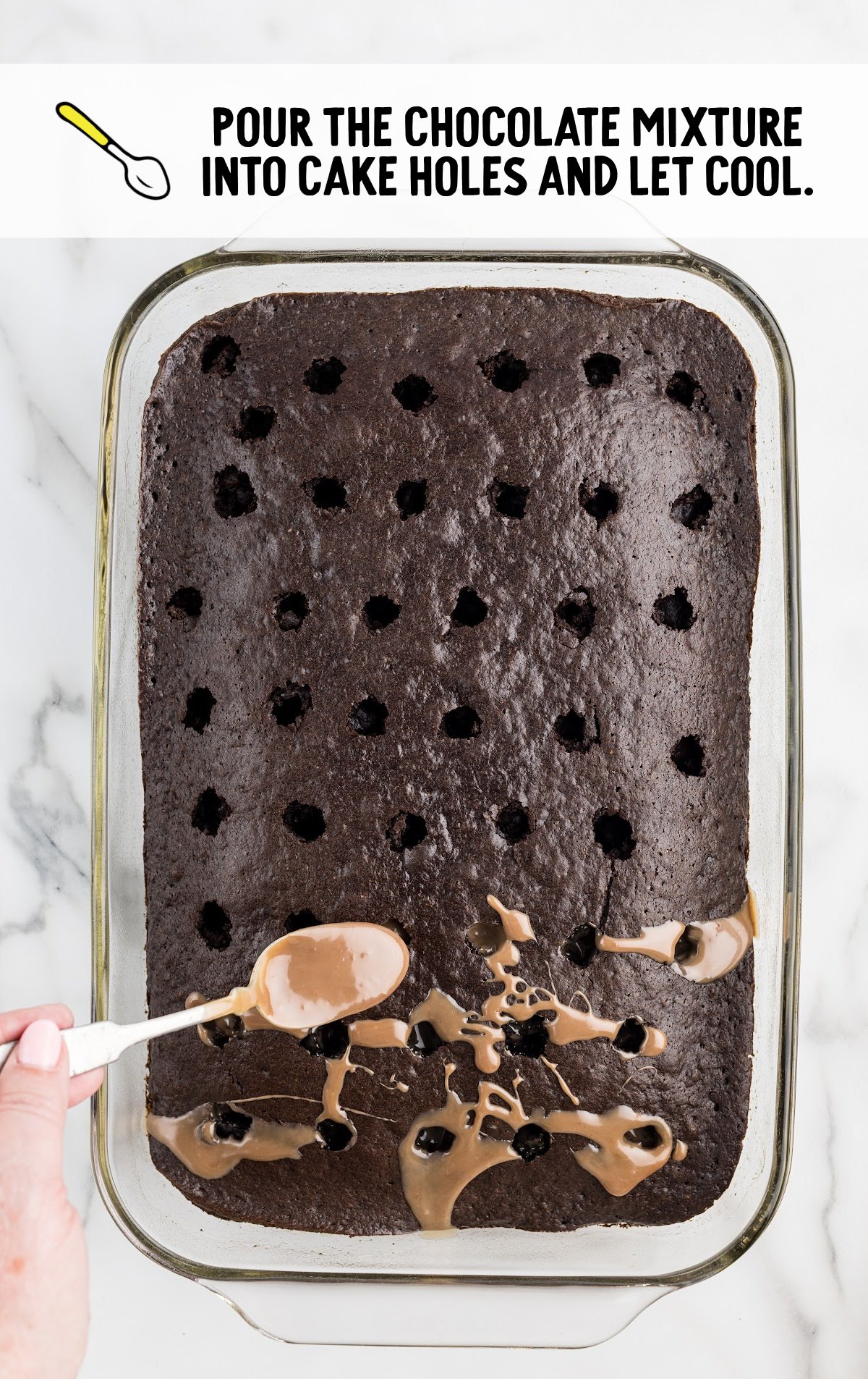 A spoon is pouring the mixture into the holes in the cake.