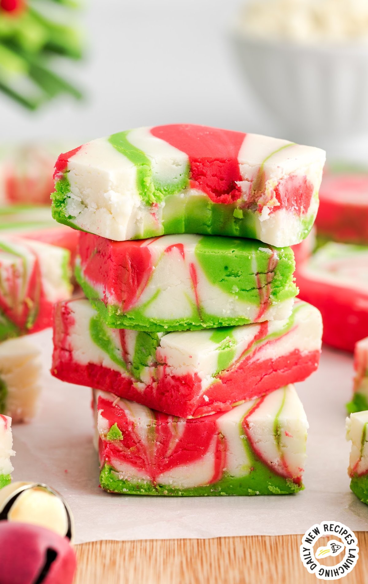 Four pieces of christmas fudge stacked. The top one has a bite out of it. 