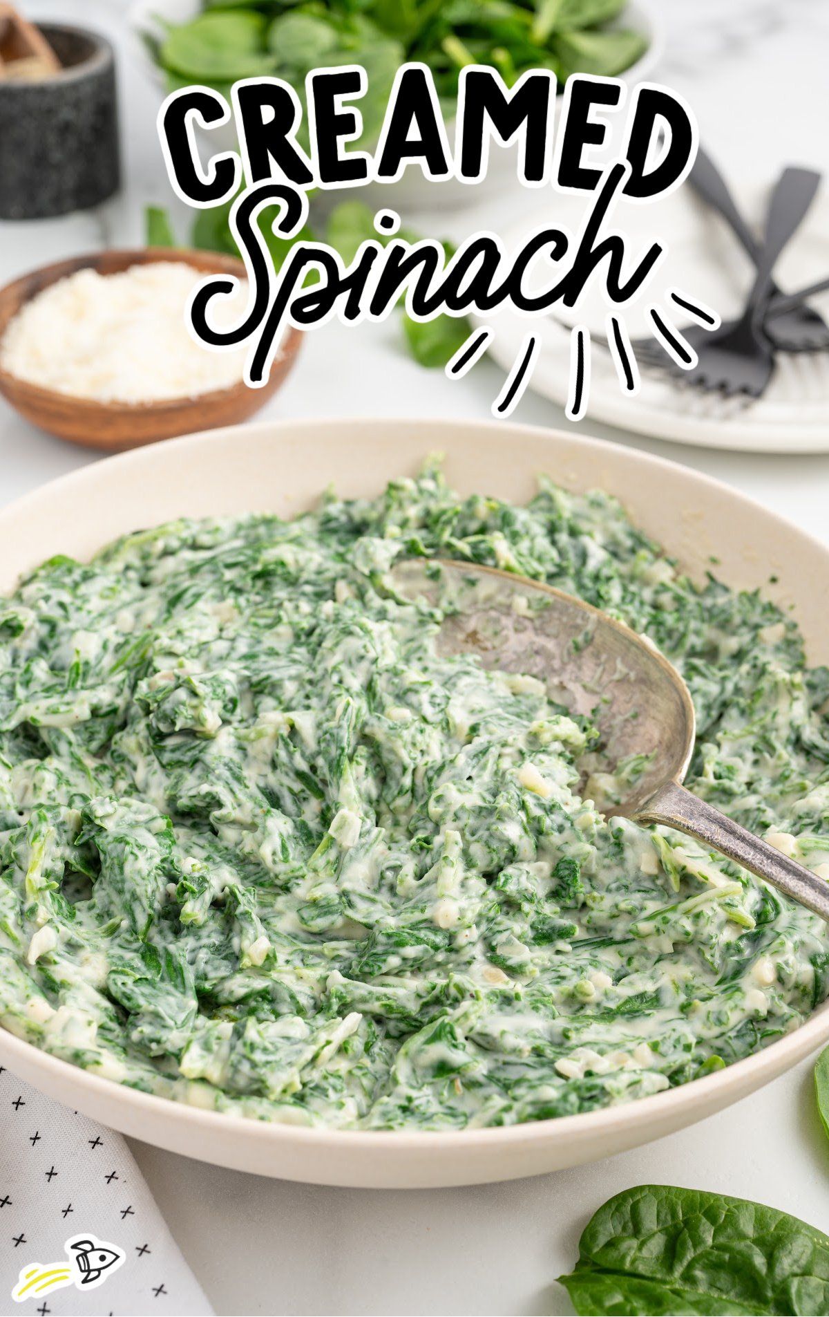 a bowl of creamed spinach with a spoon