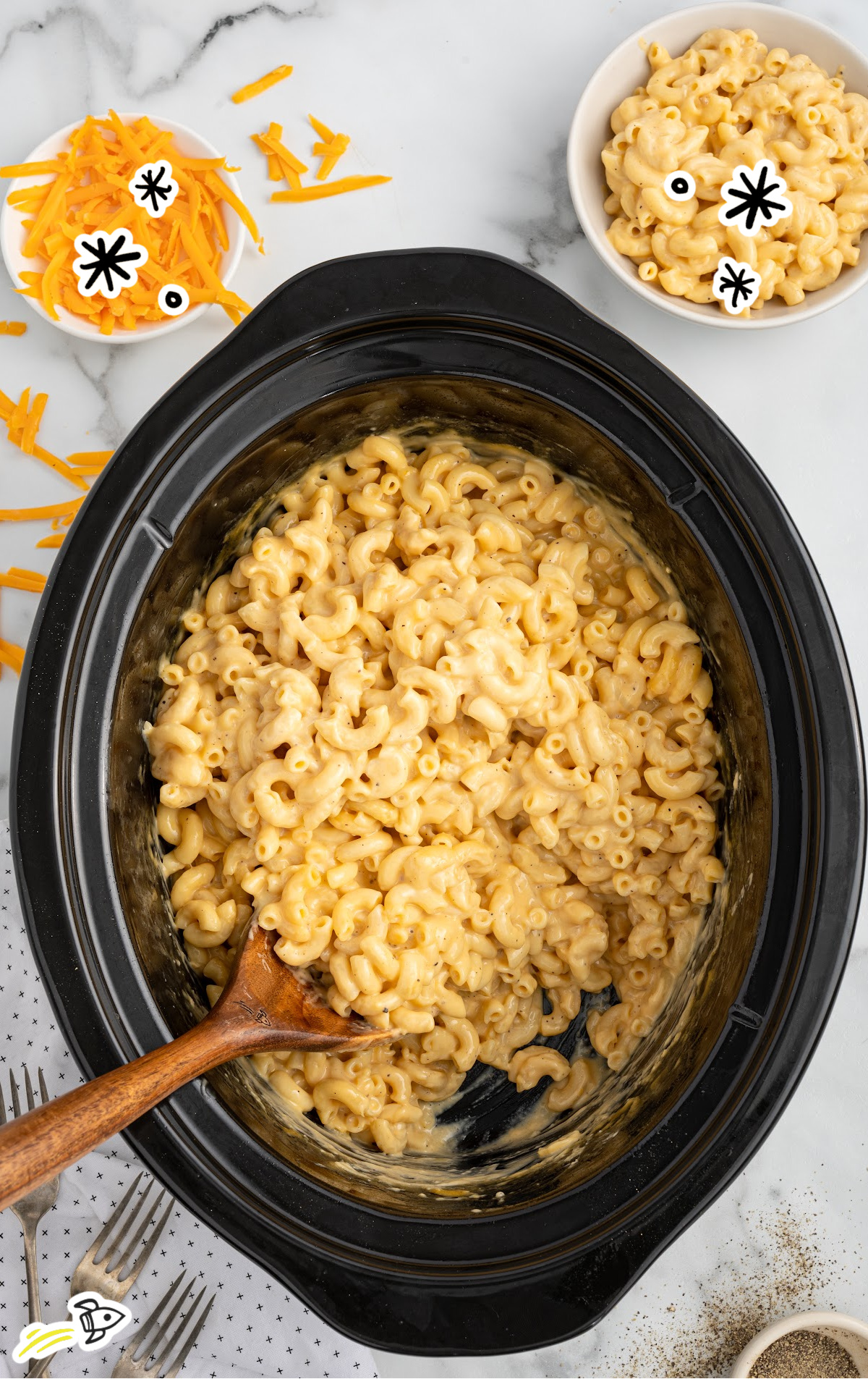 a crockpot of velveeta mac and cheese with a large wooden spoon