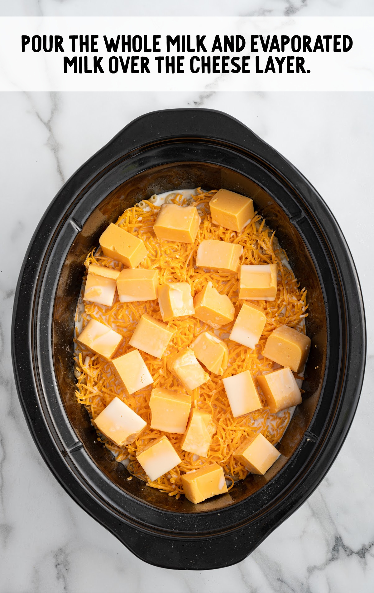 whole milk and evaporated milk poured over the cheese layer in the crockpot