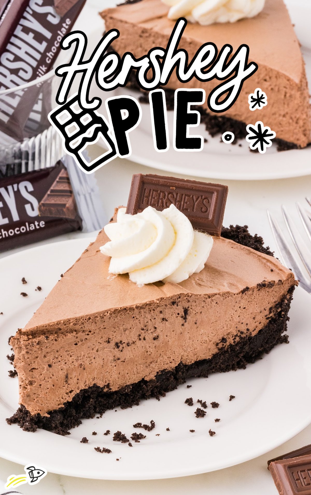 A piece of Hershey Pie on a white plate decorated with whipped cream and a mini hershey bar.