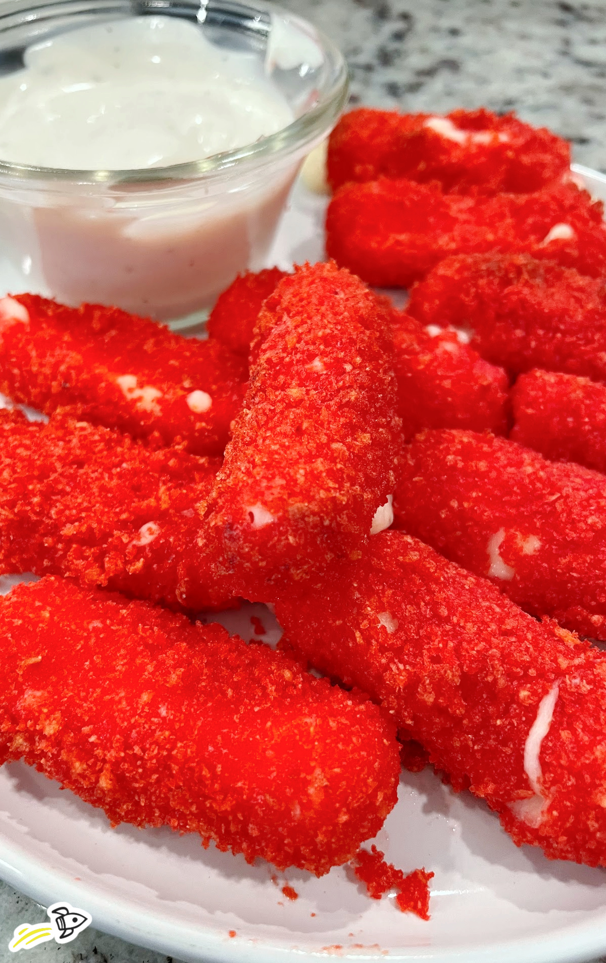 a plate of Hot Cheeto Cheese Sticks with a bowl of ranch