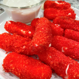 a plate of Hot Cheeto Cheese Sticks with a bowl of ranch