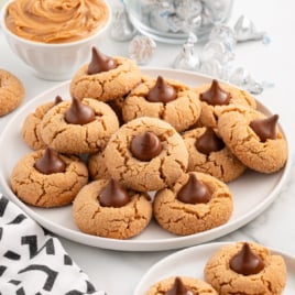 A white serving plate of Peanut Butter Blossoms.