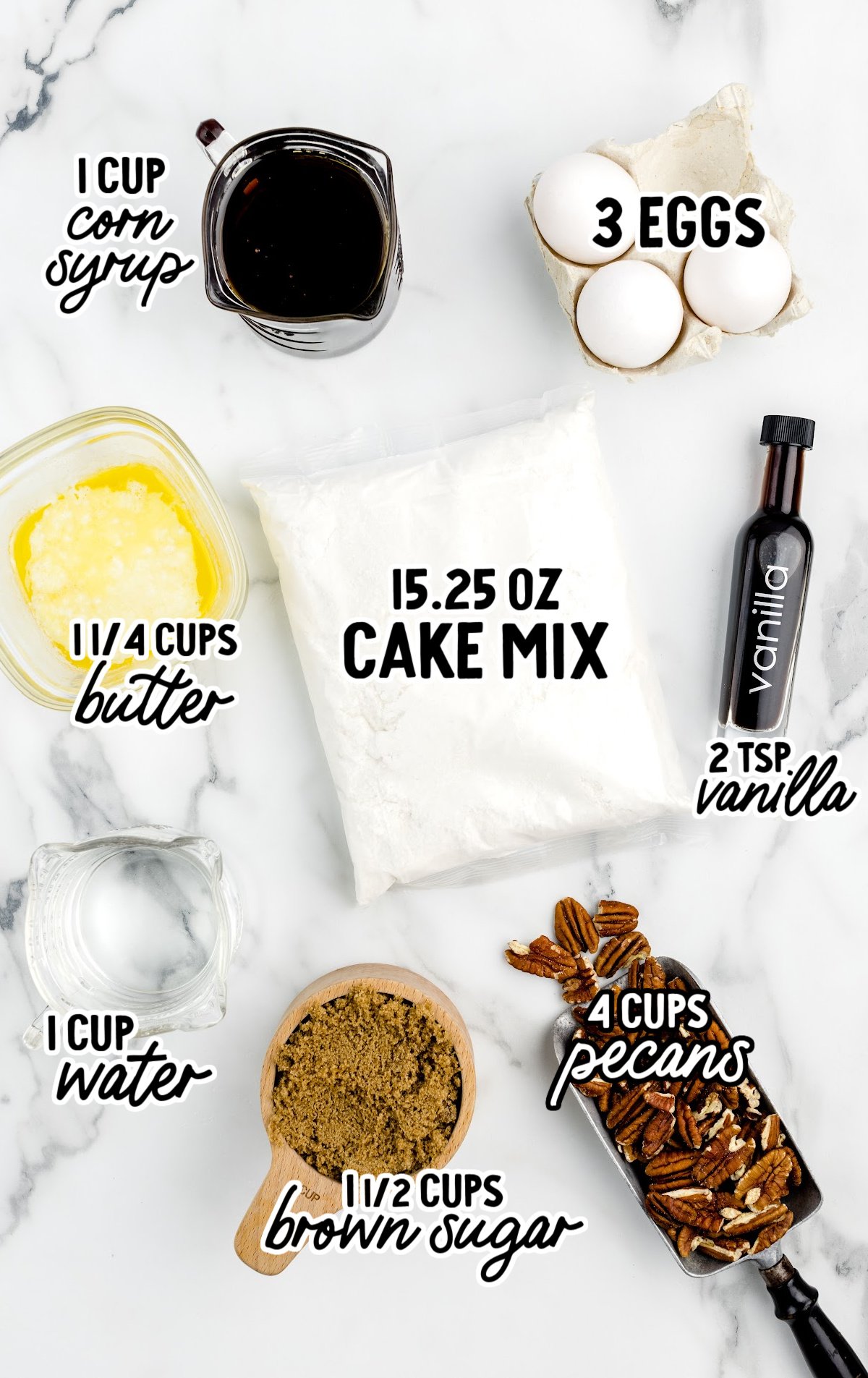 Flat lay image showing labeled ingredients for pecan dump cake on a white marble surface: 1 cup corn syrup in a glass measuring cup, 3 eggs in a carton, 15.25 oz cake mix in a sealed bag, 2 teaspoons vanilla in a dark bottle, 4 cups pecans in a metal scoop, 1½ cups brown sugar in a wooden measuring cup, 1 cup water in a glass measuring cup, and 1¼ cups melted butter in a small glass dish.