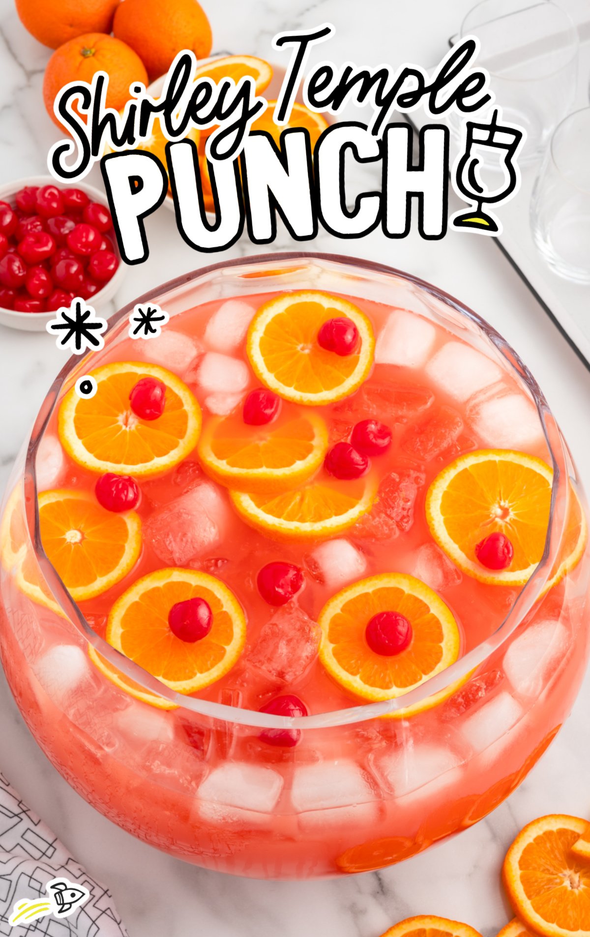 A punch bowl of shirley temple punch with oranges and cherries on top.