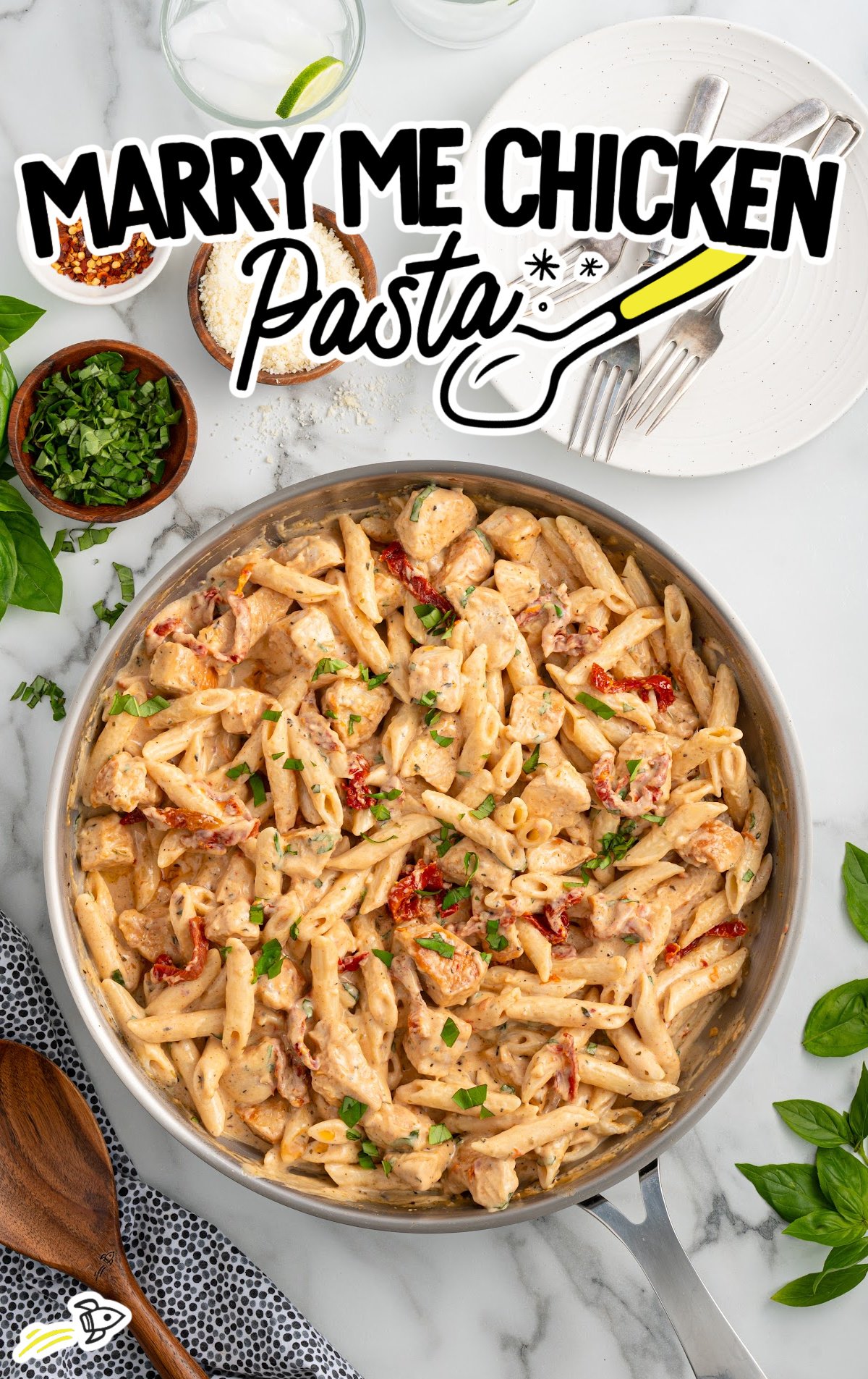 a skillet of chicken pasta garnished with basil