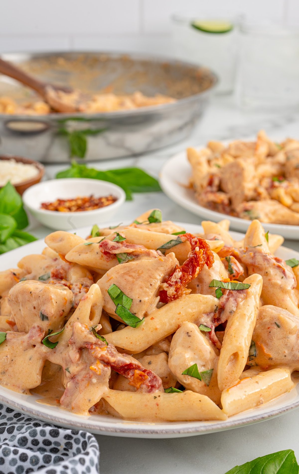 a plate of chicken pasta garnished with basil