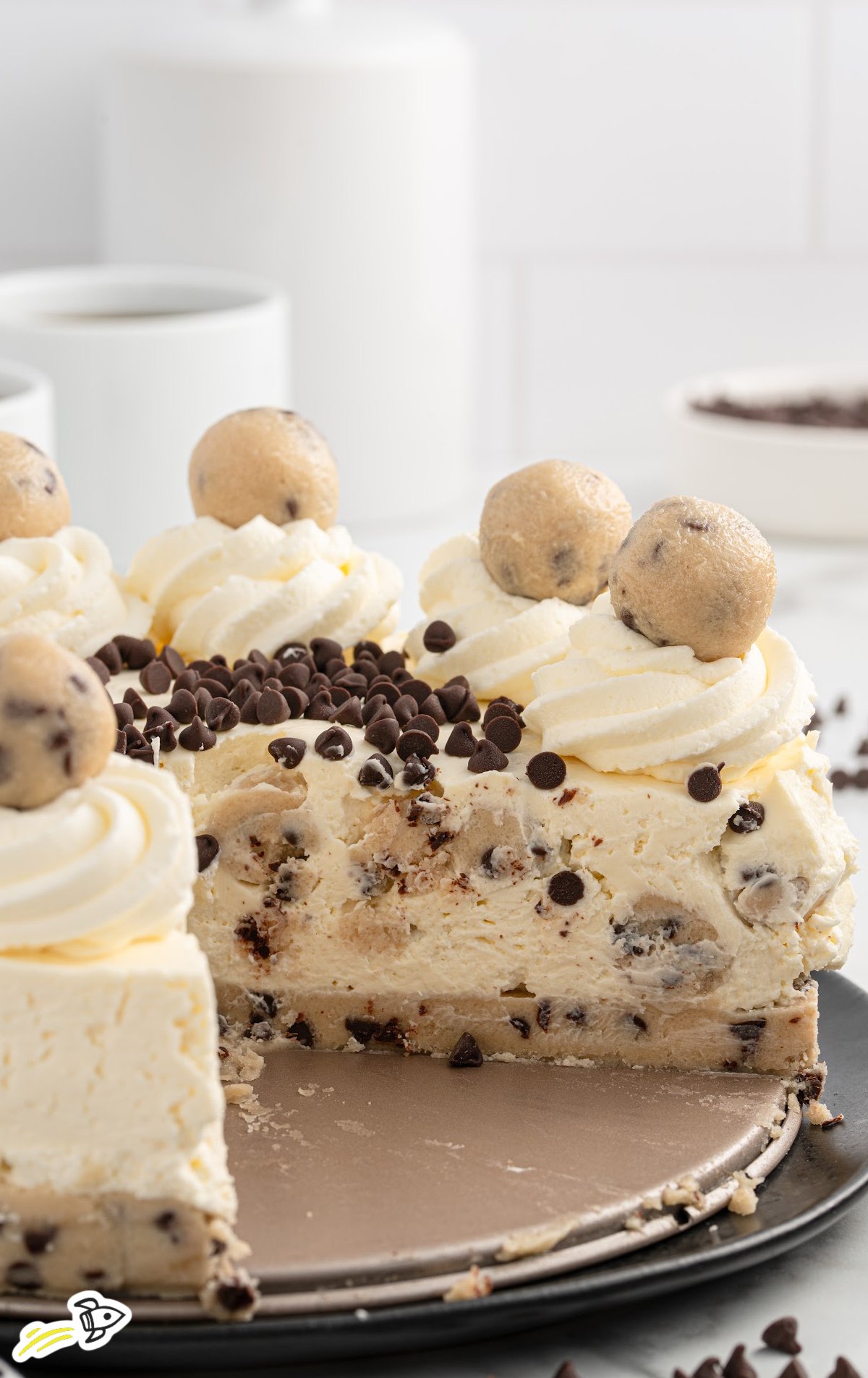 Cookie Dough Cheesecake topped with chocolate chips, whipped cream, and a cookie dough ball