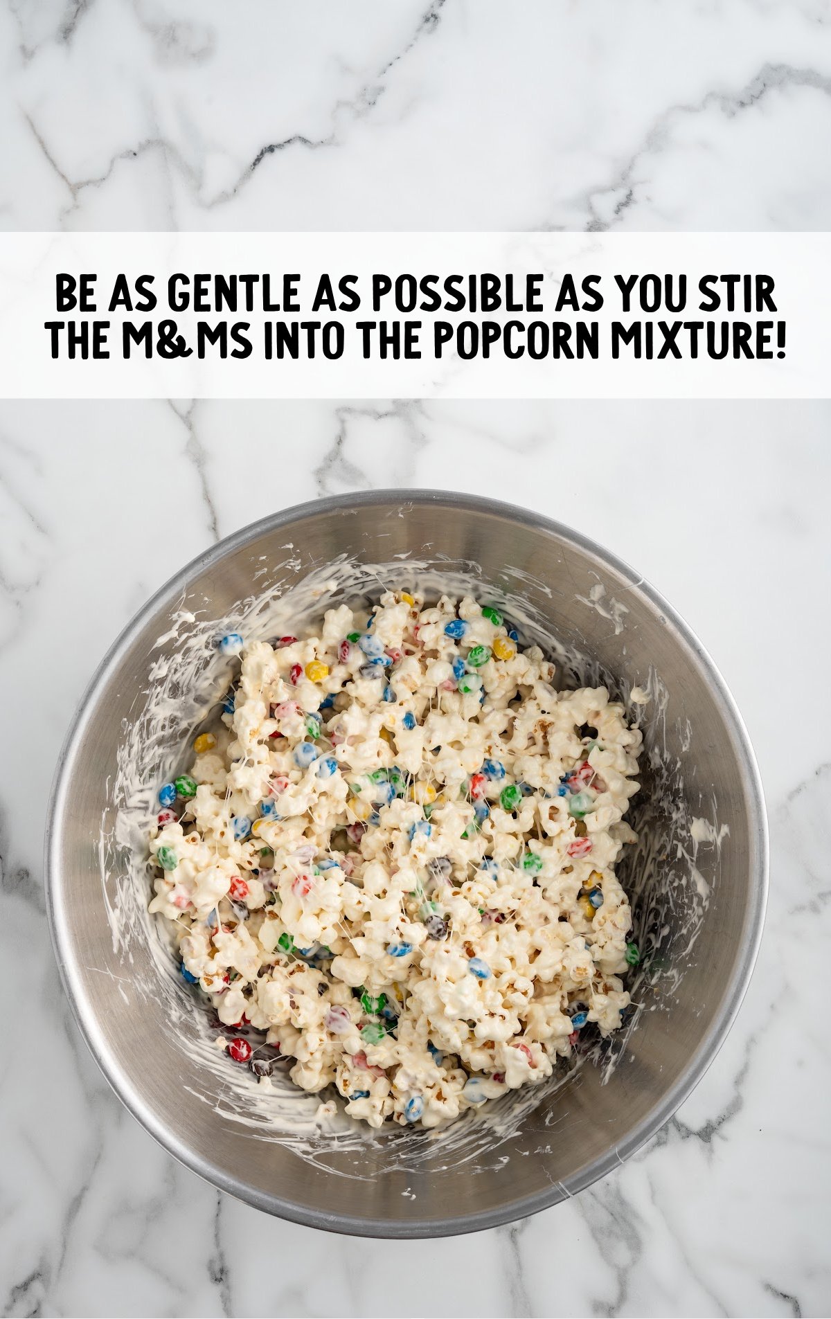 m&m's stirred into the popcorn mixture