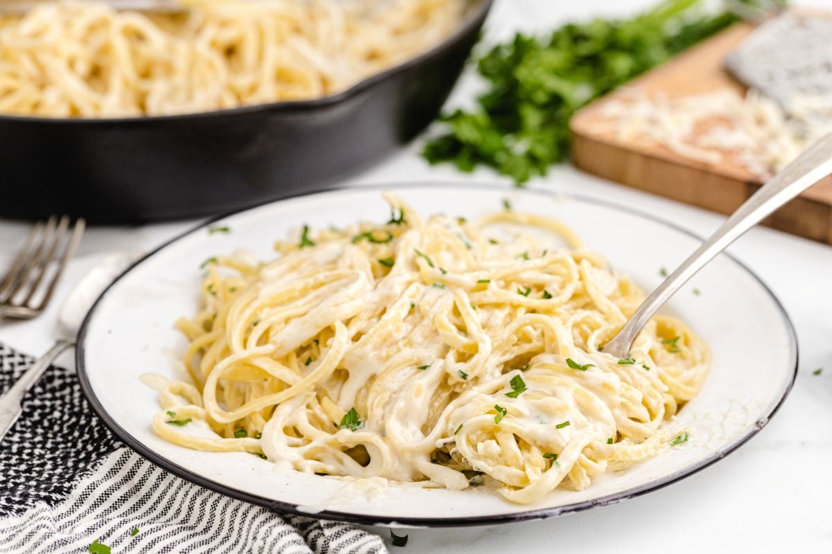 copycat olive garden alfredo pasta on white plate with fork