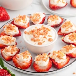Finished deviled strawberries topped with cheesecake filling and strawberry crunch garnish