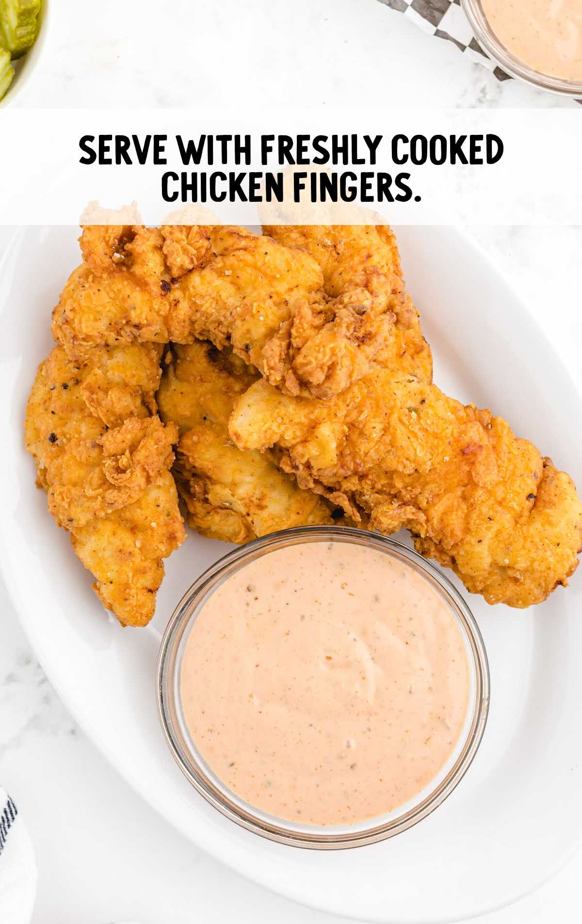 chicken fingers and a bowl of dipping sauce on a plate