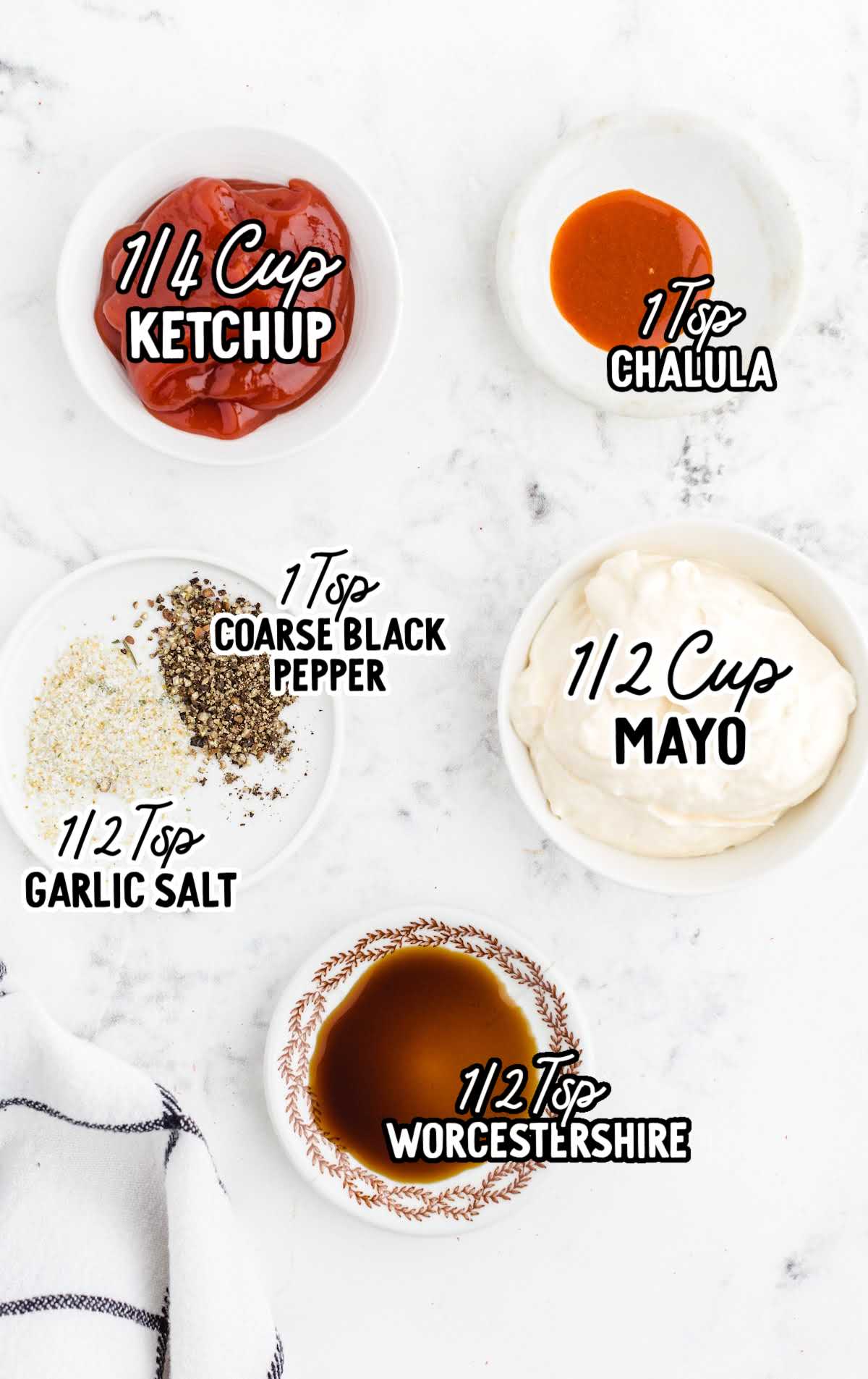 Overhead view of labeled ingredients in small bowls for chicken finger dipping sauce, including mayo, ketchup, hot sauce, black pepper, garlic salt, and Worcestershire sauce.