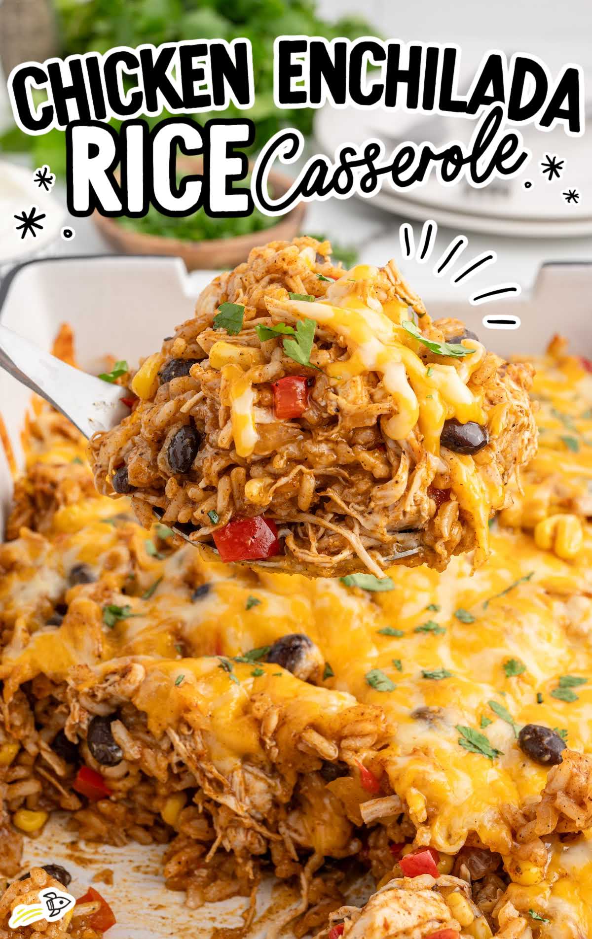 A close-up of a serving of chicken enchilada rice casserole on a spatula, showcasing the cheesy, vibrant dish with shredded chicken, black beans, corn, and melted cheese, garnished with fresh cilantro.