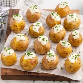 a bunch of mini baked potatoes topped with sour cream and chives