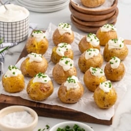 a bunch of mini baked potatoes topped with sour cream and chives