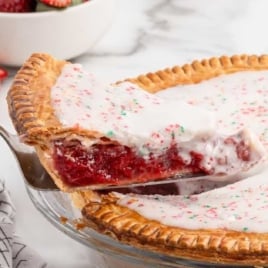 a slice of Strawberry Pop Tart Pie taken out of the whole pie